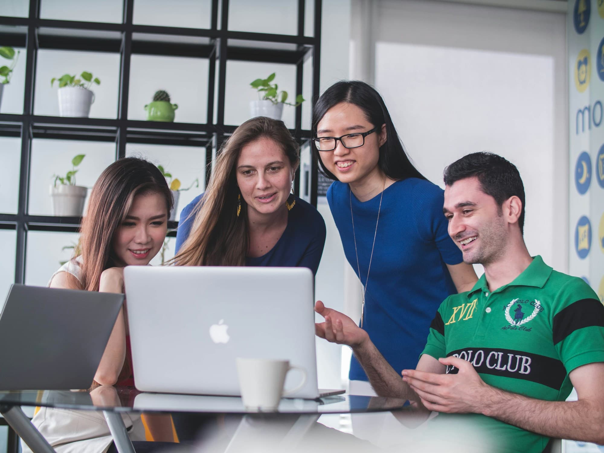 A team collaborating around a laptop